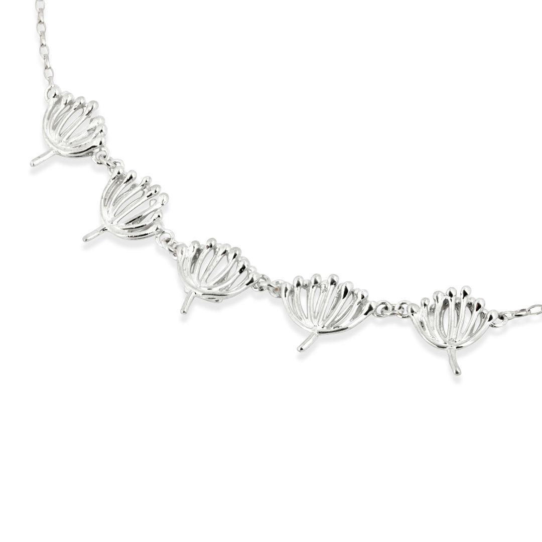 An necklet on a white background which depicts cow parsley designed by Aurora Jewellery Orkney