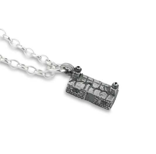 Silver necklace with a cottage pendant on a white background