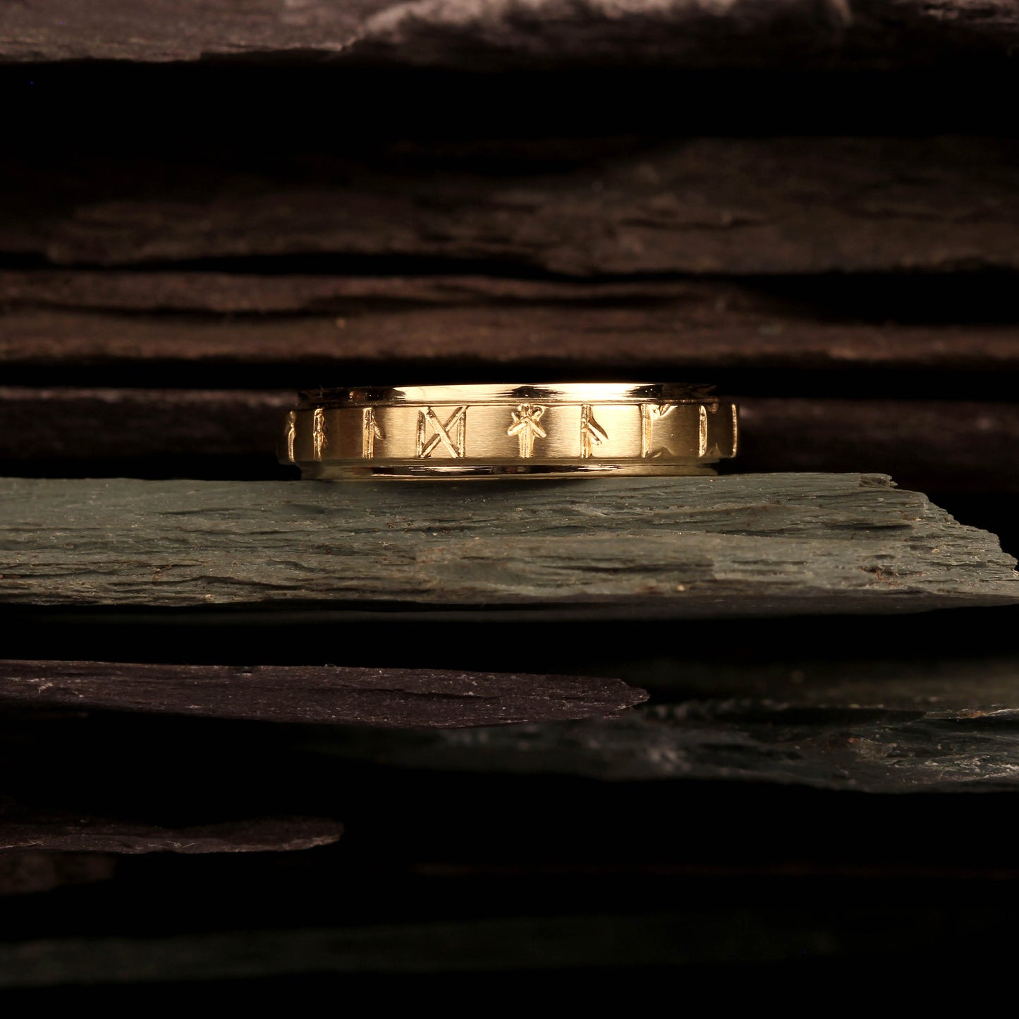 celtic wedding ring. Runic Ring 4mm Gold 26032-1 - Displayed on a slate, Aurora Orkney Jewellery, Orkney, Scotland