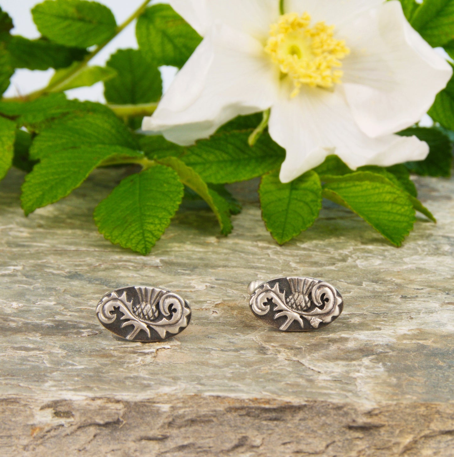 Outlander Rose Coin Collection Thistle Cufflinks on a slate background with rose by Aurora Jewellery, Orkney, Scotland