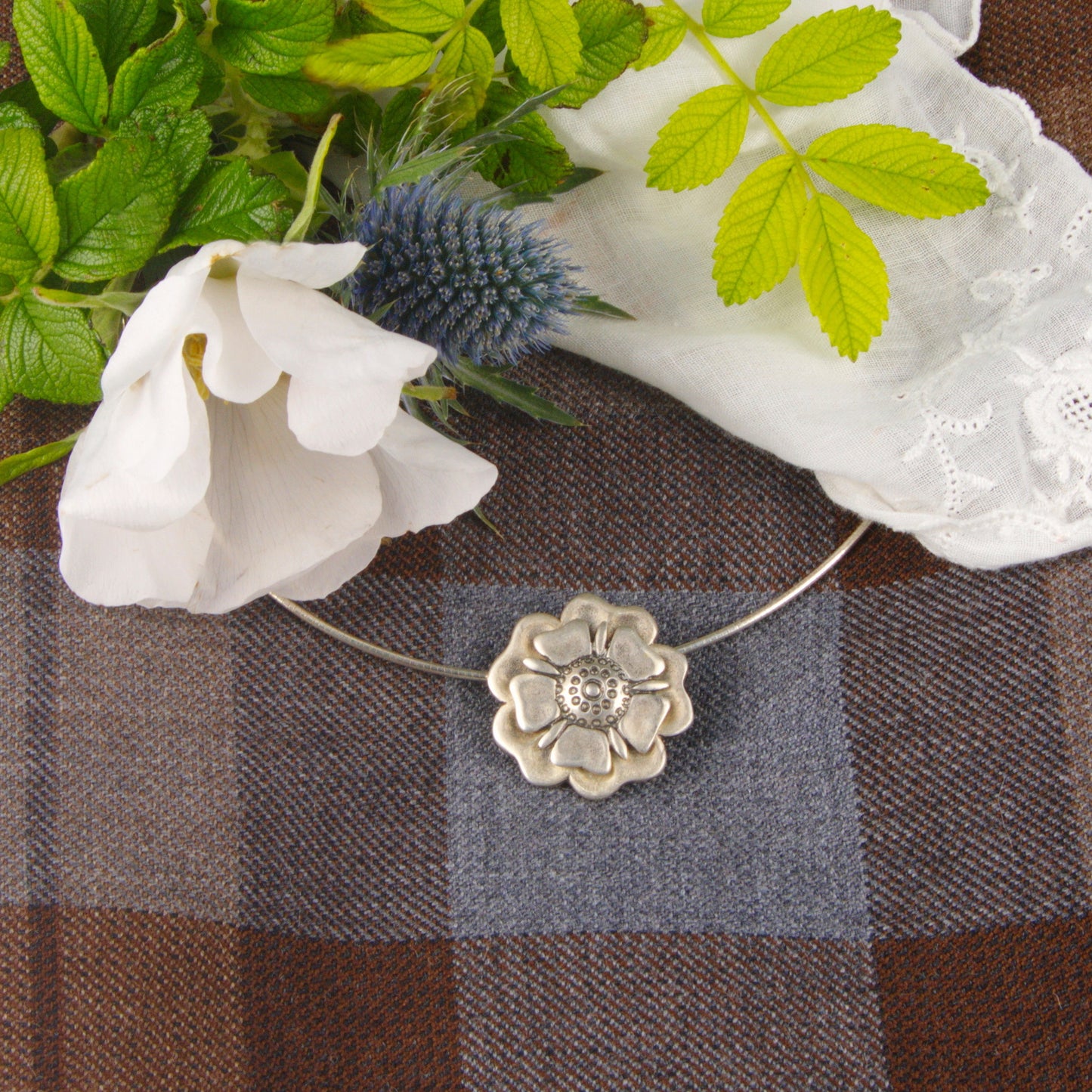Outlander Jacobite Rose Coin Collection necklace with rose charm on a tartan background with rose by Aurora Jewellery, Orkney, Scotland