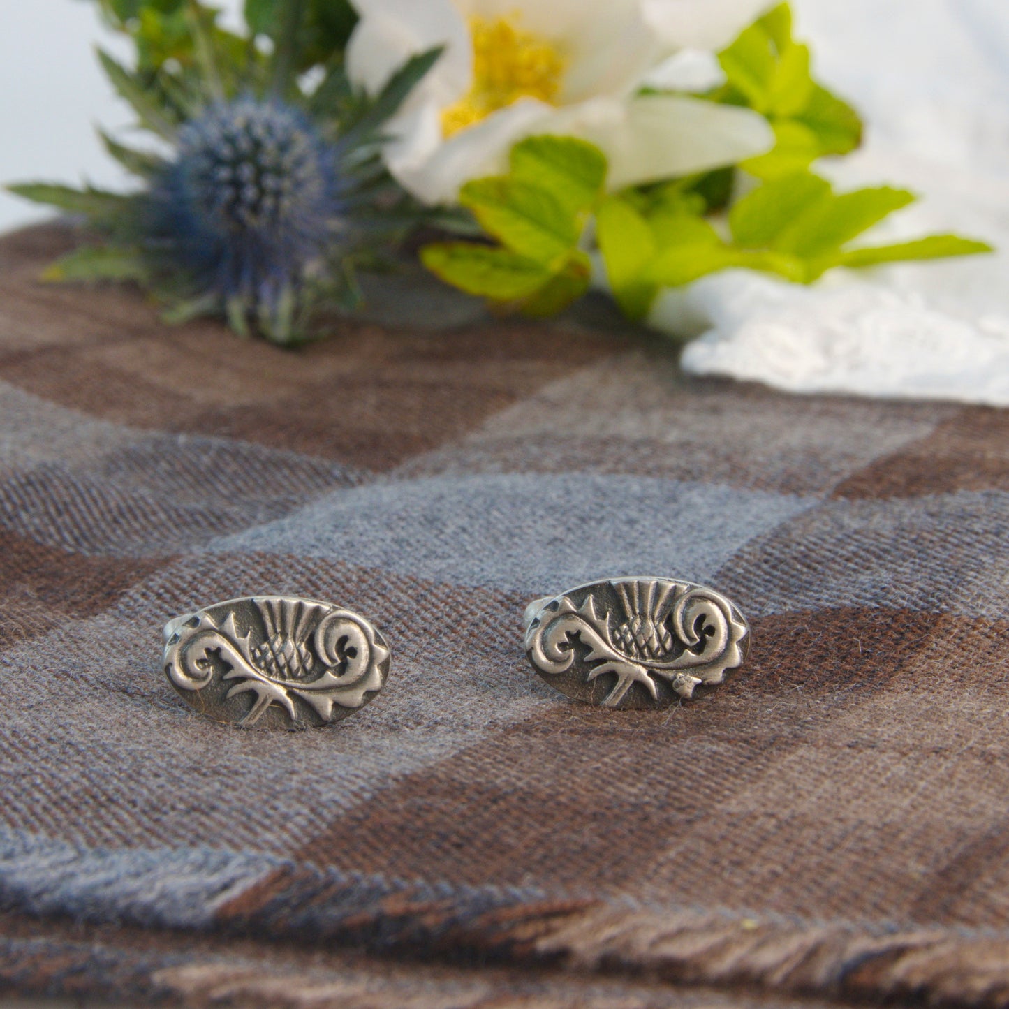 Outlander Rose Coin Collection Thistle Cufflinks on a tartan background with rose and thistle by Aurora Jewellery, Orkney, Scotland